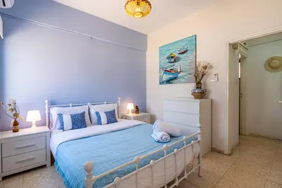 a bedroom with a bed with blue sheets and blue pillows at Sea Breeze 1-BR Apt in Pyla in Pyla