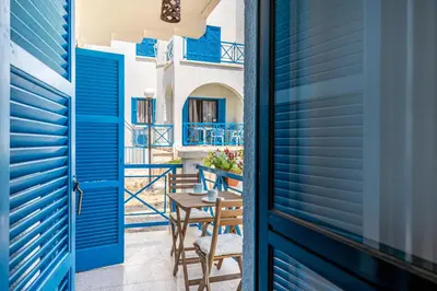 a door leading to a balcony with blue shutters at Sea Breeze 1-BR Apt in Pyla in Pyla