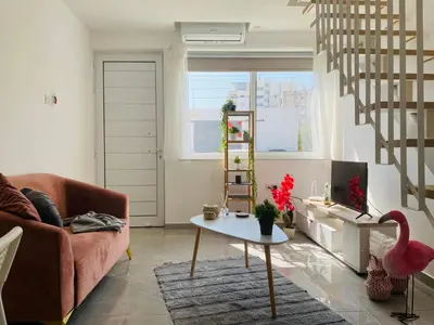 a living room with a pink couch and a table at Pink Flamingo 1-BR apartment in Larnaca in Larnaka