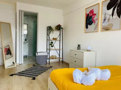 a bedroom with a yellow bed with two white towels at Pink Flamingo 1-BR apartment in Larnaca in Larnaka