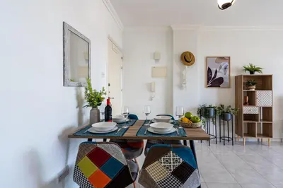 a dining room with a table with plates and wine glasses at Sweet retreat 2-BR Apartment in Mackenzie in Larnaka
