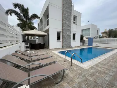 a patio with chairs and a swimming pool at Crystal 12 Kapparis 3Bedroom Villa in Paralimni
