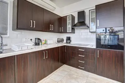 a kitchen with wooden cabinets and a counter top at Crystal 12 Kapparis 3Bedroom Villa in Paralimni