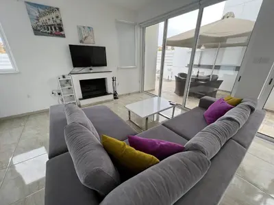 a living room with a gray couch with purple and yellow pillows at Crystal 12 Kapparis 3Bedroom Villa in Paralimni