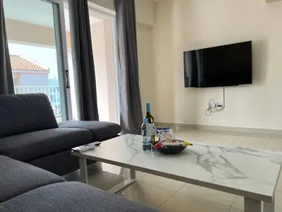 a living room with a coffee table and a tv at Greek Harmony Apartment in Paralimni