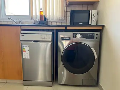 a microwave and a washing machine in a kitchen at Greek Harmony Apartment in Paralimni
