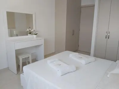a white room with a bed and a mirror at Dinglis Residences 31 in Larnaka