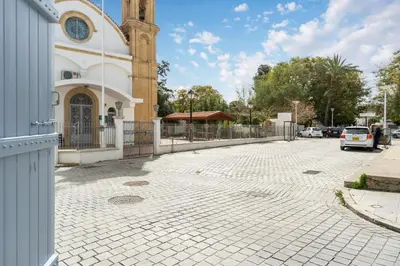 a cobblestone street in front of a building with a clock tower at To Hani - Kamara Studio in Nicosia