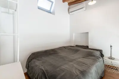 a bedroom with a bed with a gray blanket at To Hani - Kamara Studio in Nicosia