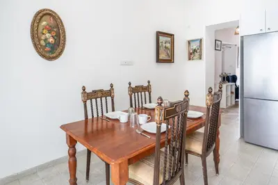 a dining room with a table and chairs and a refrigerator at To Hani - Kamara Maisonette in Nicosia