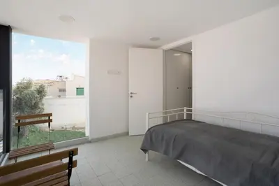a bedroom with a bed and a large window at To Hani - Kamara Maisonette in Nicosia