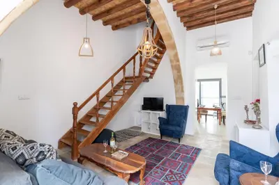 a living room with a spiral staircase and blue chairs at To Hani - Kamara Maisonette in Nicosia