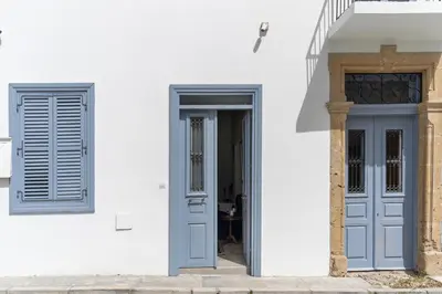 a white building with two doors on it at To Hani - Kamara Maisonette in Nicosia