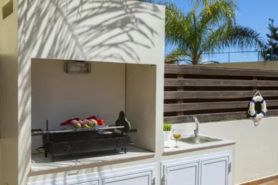 a kitchen with a sink and a bowl of fruit at Tsokkos Family Villa - Pool Garden 2' Walk to Beach in Protaras