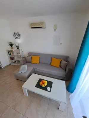 a living room with a couch and a table at AFRODITI APARTMENTs in Pervolia