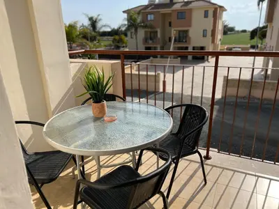 a glass table and chairs on a balcony at AFRODITI APARTMENTs in Pervolia