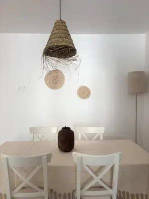 a dining room with a table with white chairs and a basket at Hestia Living in Scala