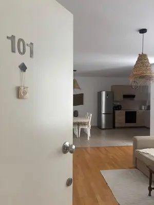a open door to a living room with a kitchen at Hestia Living in Scala
