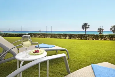 a table with a glass of wine and a plate of food at Villa Napa Seaside in Ayia Napa