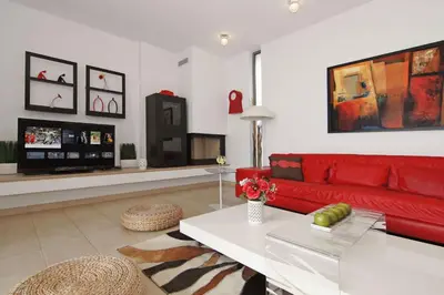 a living room with a red couch and a table at Villa Napa Seaside in Ayia Napa