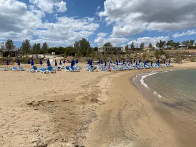 a beach with chairs and umbrellas and the ocean at Great Kings Resort, Kapparis, Cyprus - Self Catering Apartment, Sleeps 6 in Paralimni
