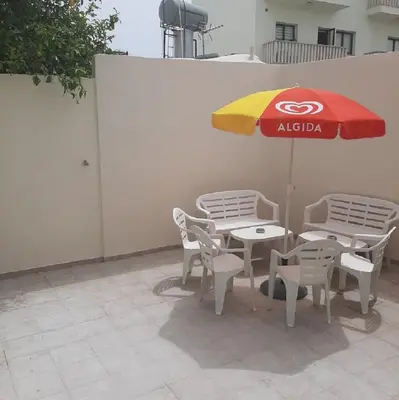 a table and chairs with an umbrella on a patio at HAVEN HOUSE in Larnaka