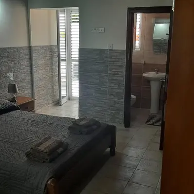 a bedroom with a bed and a bathroom with a sink at HAVEN HOUSE in Larnaka