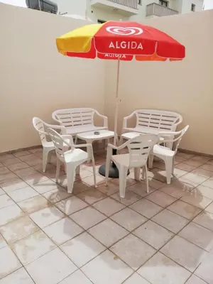 a table and chairs and an umbrella on a tiled floor at HAVEN HOUSE in Larnaka