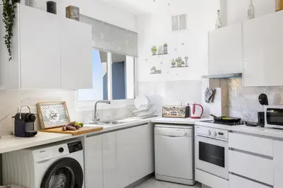 a white kitchen with a dishwasher and a washer at Lovely 3-bedroom apartment in Prokymea court in Limassol