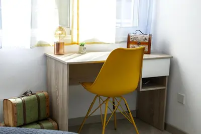 a desk with a yellow chair next to a window at Lovely 3-bedroom apartment in Prokymea court in Limassol