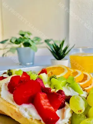 a sandwich with fruit on a plate on a table at Milos City Center Apt. 32 in Larnaka