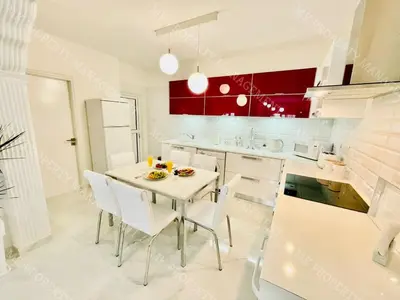 a white kitchen with a table and white chairs at Milos City Center Apt. 32 in Larnaka