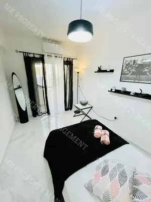 a room with a bed with pink shoes on it at Milos City Center Apt. 32 in Larnaka