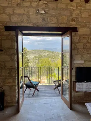 an open door to a patio with a couch and a fireplace at myLofou in Lofou