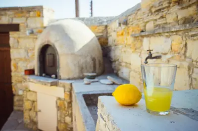 a glass of orange juice and a lemon on a table at myLofou in Lofou