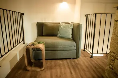 a green chair with a pillow in a room at myLofou in Lofou