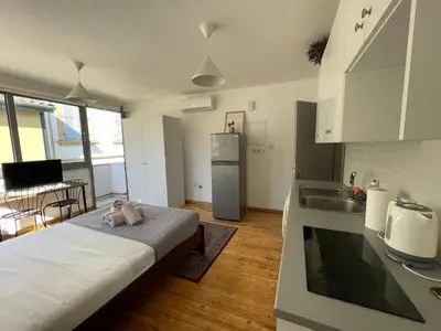 a room with a bed and a kitchen with a refrigerator at Irida - Studio Down Town Nicosia in Nicosia