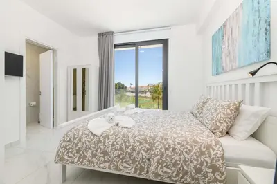 a bedroom with a bed and a large window at By The Beach - Royal Sapphire Villa in Protaras