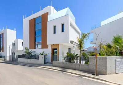 a white building on the side of a street at By The Beach - Royal Sapphire Villa in Protaras
