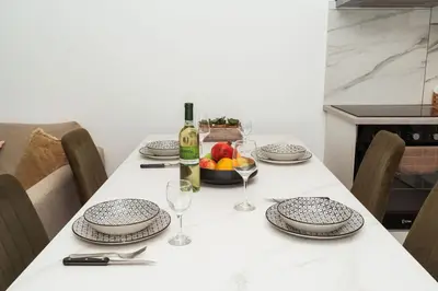 a table with a bottle of wine and a bowl of fruit at SerenityOne - Centrally located One Bedroom Apt in Ayia Napa
