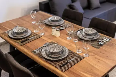 a wooden table with plates and hats on it at SerenityOne - Centrally located One Bedroom Apt in Ayia Napa