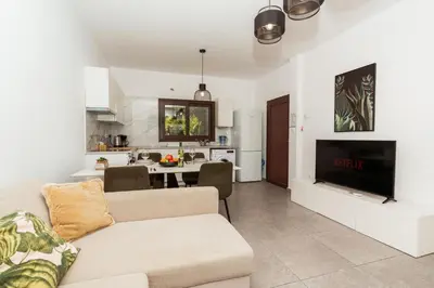 a living room with a couch and a kitchen at SerenityOne - Centrally located One Bedroom Apt in Ayia Napa