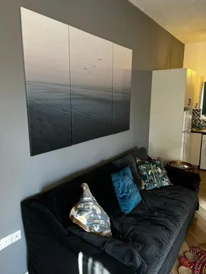 a black couch in a living room with a picture on the wall at Ayia napa rest in Ayia Napa