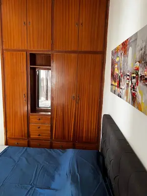 a bedroom with a bed and wooden cabinets at Ayia napa rest in Ayia Napa