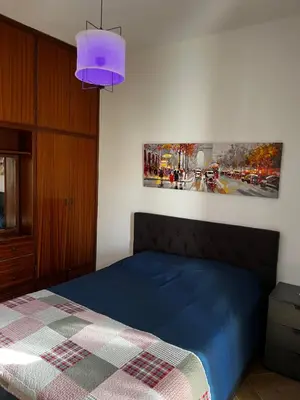 a bedroom with a blue bed and a purple lamp at Ayia napa rest in Ayia Napa