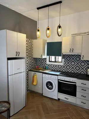 a kitchen with white cabinets and a dishwasher at Ayia napa rest in Ayia Napa