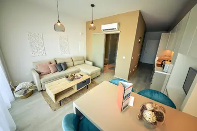 a living room with a couch and a table at De Lux Mythical SPA 9 in Paralimni