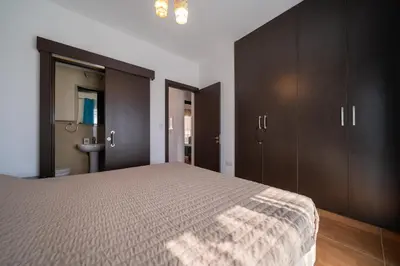 a bedroom with a large bed and wooden cabinets at Anna-Maria 3 bedroom villa in Paralimni