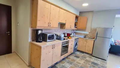 a kitchen with wooden cabinets and a white refrigerator at STAY Kapparis Horizon in Paralimni