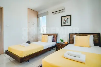 a bedroom with two beds with yellow sheets at Villa Seaview in Protaras
